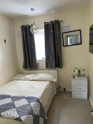 a bedroom with a bed and a window with curtains at Single room with Smart Tv in Luton