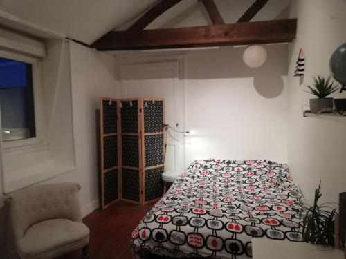 une chambre avec un lit, une chaise et une fenêtre dans l'établissement Maison, Cité Plantagenêt, 20 m de la parade des pilotes 24 h, 20 mn en tram du circuit, au Mans
