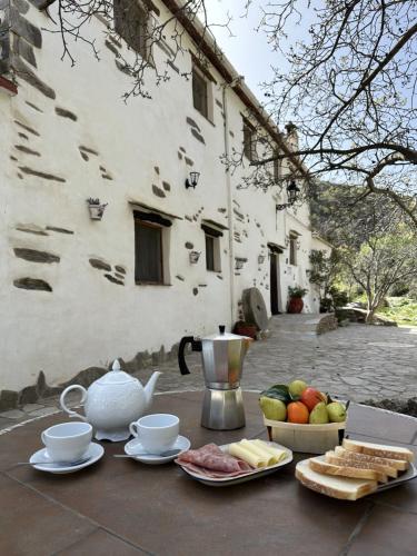 - une table avec une théière et un bol de fruits dans l'établissement Molino Laroya, à Laroya