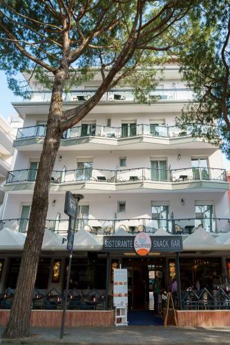 a large white building with a sign in front of it at Hotel Kennedy in Lido di Jesolo