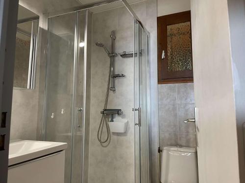 uma casa de banho com um chuveiro, um WC e um lavatório. em Maison Fleury-Saint-Pierre-la-Mer, 2 pièces, 6 personnes - FR-1-229D-29 em Fleury