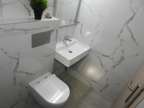 a white bathroom with a toilet and a sink at Sandra's luxury stay in Akti Salonikiou