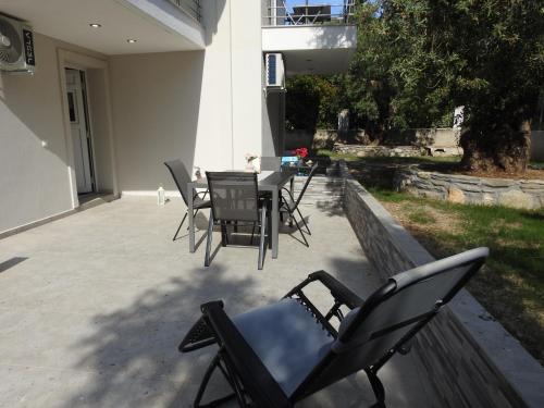 a patio with chairs and a table in a yard at Sandra's luxury stay in Akti Salonikiou