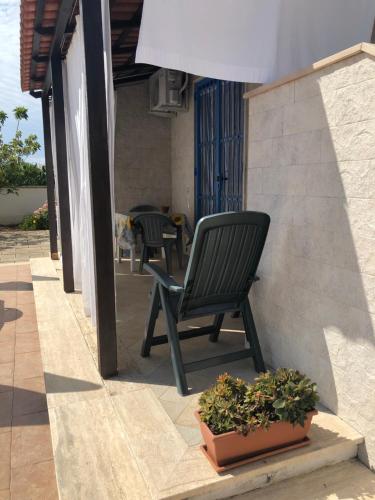 a black chair sitting on a patio with a potted plant at Sirenetta in Torre Suda