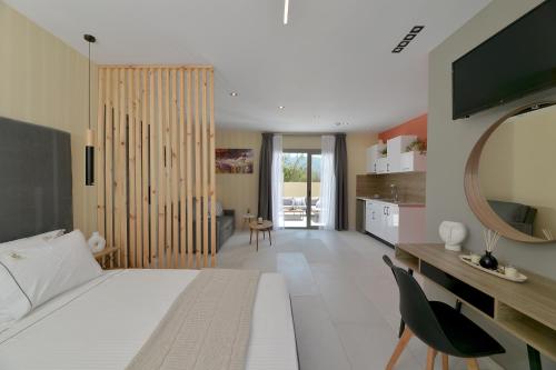 a bedroom with a large white bed and a kitchen at Swan Paradise Residences in Loutra Oraias Elenis