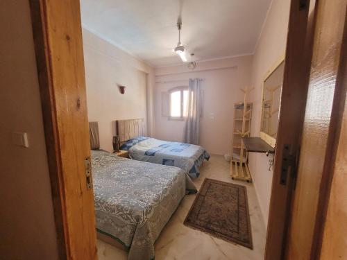 a small room with two beds and a window at Villa Medinet Habu avec piscine privée in Luxor