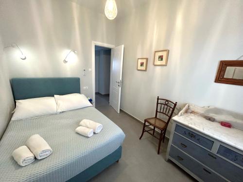 1 dormitorio con cama, silla y vestidor en Villa DALI Danae, en Fira