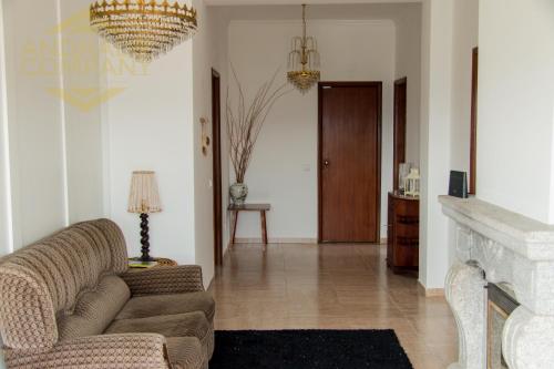 a living room with a couch and a chandelier at Casa da Calçada in Pinhão