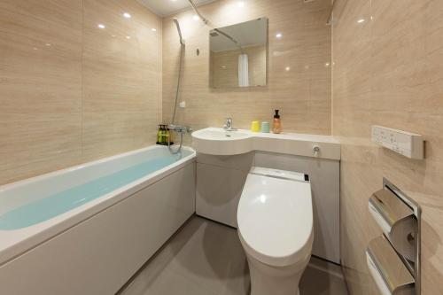 a bathroom with a toilet and a sink and a bath tub at Azumakan in Nihommatsu
