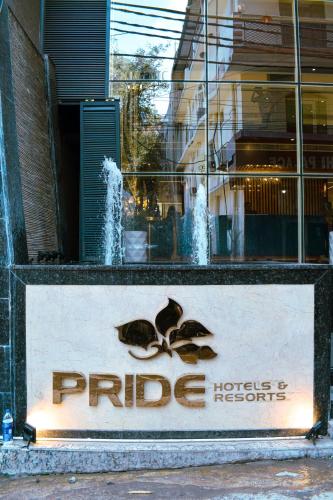 a store sign in front of a building with water fountain at Pride Hotel And Resort Rishikesh in Rishīkesh