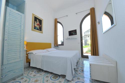 a white room with a bed and two windows at Casa Patty...Breath-taking view! in Positano