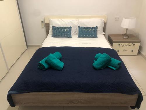 a bedroom with a large bed with green pillows at Stanza vicino Paceville e San Giuliano in Is-Swieqi