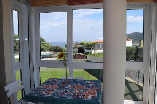 a table with a vase on top of a window at Vistas al mar in Porto de Espasante