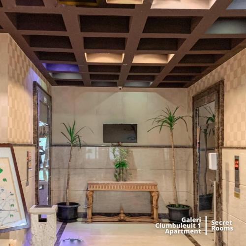 a room with a bench and a tv on a wall at Ciumbuleuit Apartment by Secret Rooms in Bandung