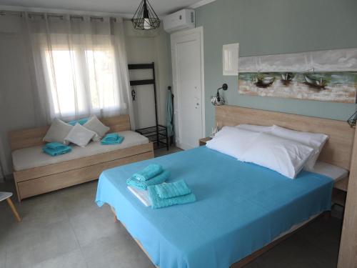a bedroom with a blue bed with towels on it at Sandra's luxury stay in Akti Salonikiou