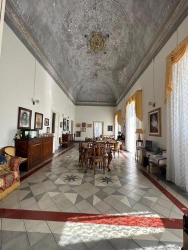 sala de estar con mesa, sillas y techo en La Dimora Del Barone, en Vernole