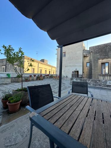a wooden table and chairs on a patio at La Dimora Del Barone in Vernole