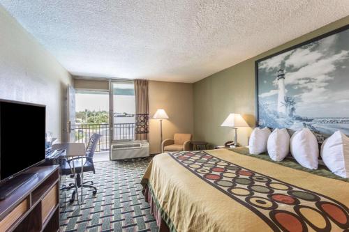 a hotel room with a bed and a flat screen tv at Super 8 by Wyndham Ocala I-75 in Ocala