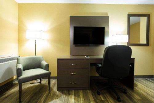 a room with a desk and a chair and a television at Days Inn by Wyndham Fallsview in Niagara Falls