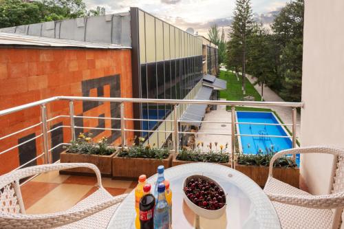 a balcony with a table with drinks and a bowl of fruit at Arzni Health Resort in Arzni