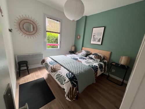 a bedroom with a bed with green walls and a mirror at Urdina in Saint-Jean-de-Luz