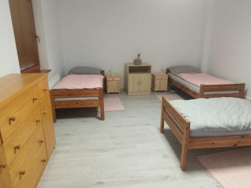 a room with three beds and a dresser at Ubytovanie Vo dvore in Badín