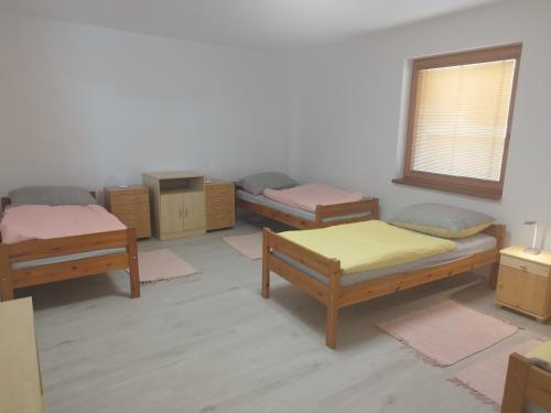 um quarto com três camas e uma janela em Ubytovanie Vo dvore em Badín