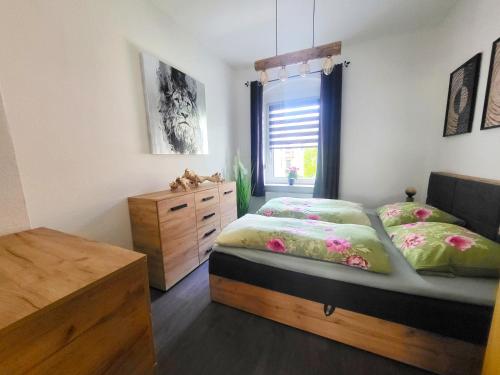 una camera da letto con due letti e una finestra di Ferienwohnung SehrGemütlich in Sachsen a Lichtenstein