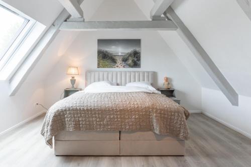 a white attic bedroom with a bed and two lamps at Nordisch noble Lebensart WE 1 in Bargum