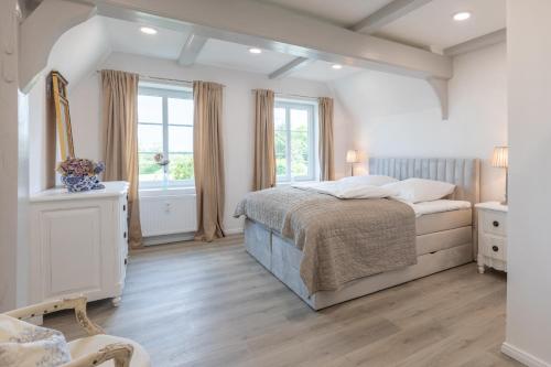 a bedroom with a bed and a large window at Nordisch noble Lebensart WE 2 in Bargum