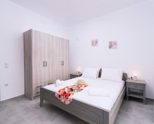 a bedroom with a large bed with a wooden cabinet at Lychnos apartments in Kamilari