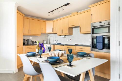 a kitchen with a table with blue bowls on it at 5 mins from the Eden Project Baybreeze Holiday Apartment, Sea Views, Super Kingsize Beds in St Austell