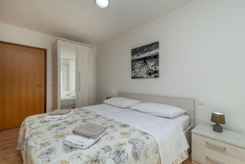 - une chambre avec un grand lit et des serviettes dans l'établissement Apartmani Grga, à Trogir