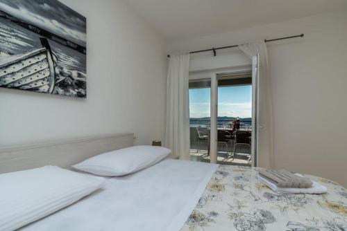 a bedroom with a bed and a view of the ocean at Apartmani Grga in Trogir