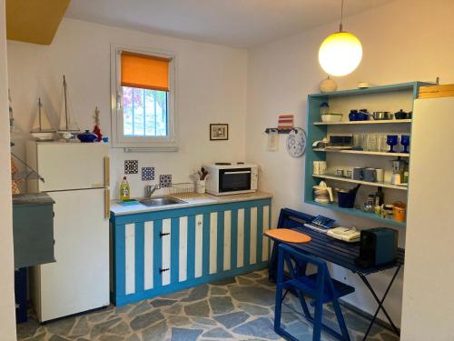 a kitchen with a blue and white refrigerator and a table at Granatapfel in Porto Heli