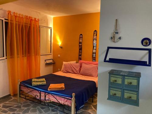 1 dormitorio con cama y pared de color naranja en Granatapfel en Porto Heli