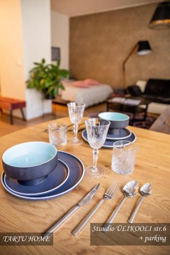 a table with plates and glasses and silverware on it at University City Heart, Tartu Home in Tartu
