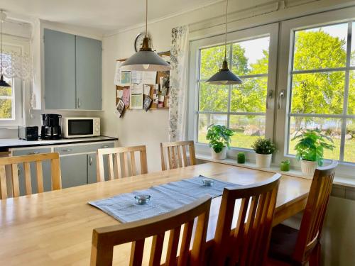 een keuken met een houten tafel met stoelen en een eetkamer bij Holiday home Småland Gäddegölshult in Gäddegölshult