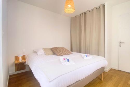 1 dormitorio con 1 cama blanca y 2 toallas en Havre de paix au cœur de la ville en Ay