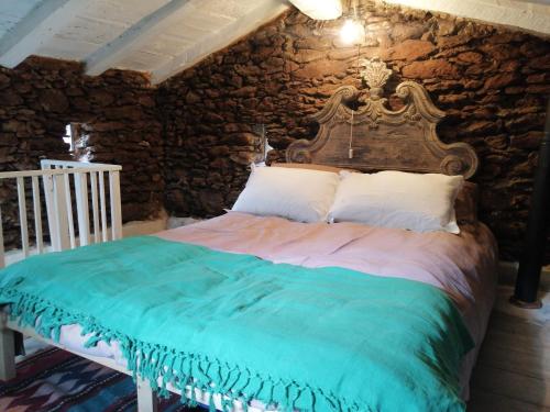 uma cama num quarto com uma parede de pedra em Il Metato di Gallena em Stazzema