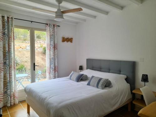 1 dormitorio con cama y ventana grande en MaCoCo Maison Coeur Corbieres, en Fontjoncouse