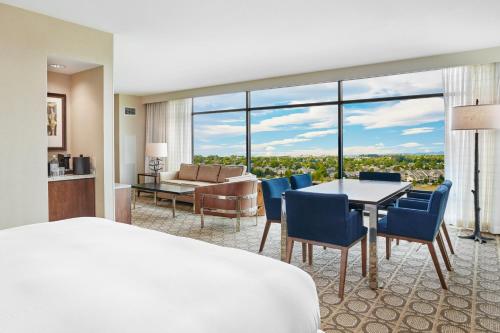 a hotel room with a bed and a dining room at Denver Marriott Westminster in Westminster