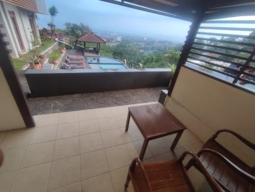 a room with a table and a chair on a balcony at Dago Highland Resort in Bandung