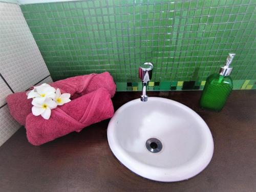 a bathroom sink with two towels and a flower on it at Bangalô Panorâmica in Conde