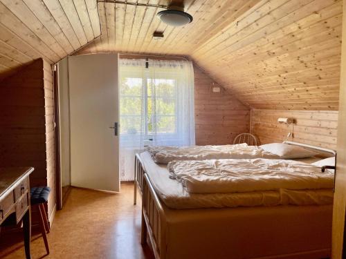 een slaapkamer met een groot bed in een houten plafond bij Holiday home Småland Gäddegölshult in Gäddegölshult