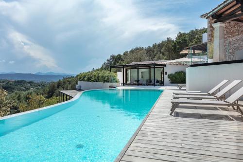 a pool with chairs and a house with a view at Hotel delle Rose a Luxury Boutique Hotel in Porto Cervo