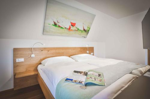 a bedroom with a white bed with a painting on the wall at Schloss Haindorf in Langenlois