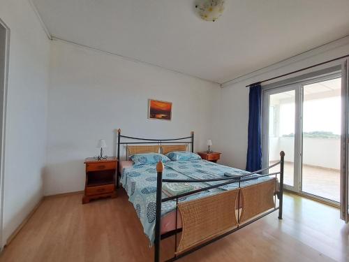 ein Schlafzimmer mit einem Bett und einem großen Fenster in der Unterkunft BenJak Apartments in Hvar