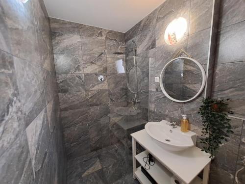 bagno con lavandino e specchio di BenJak Apartments a Hvar