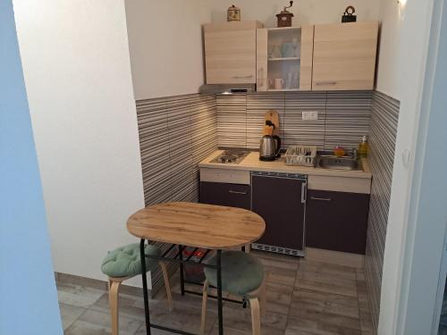 una pequeña cocina con mesa de madera y sillas en BenJak Apartments, en Hvar